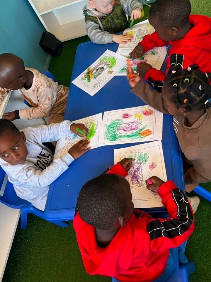 Learners colouring together at a table